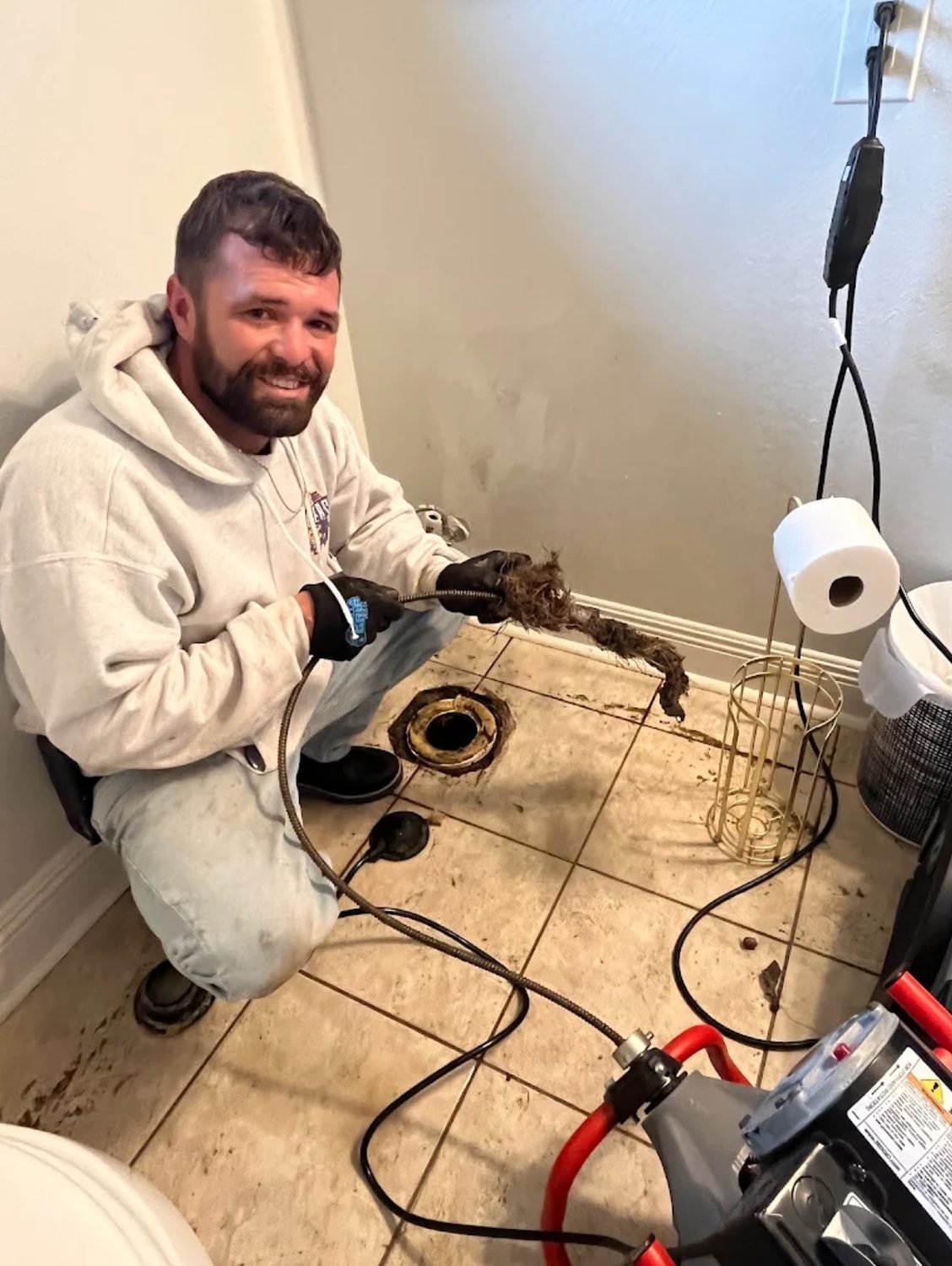 Technician holding up the blockage pulled out of a line