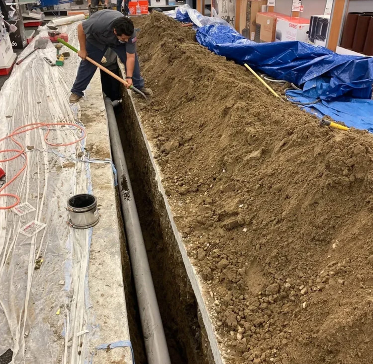 Long trench cut through a retail store floor for a new sewer line