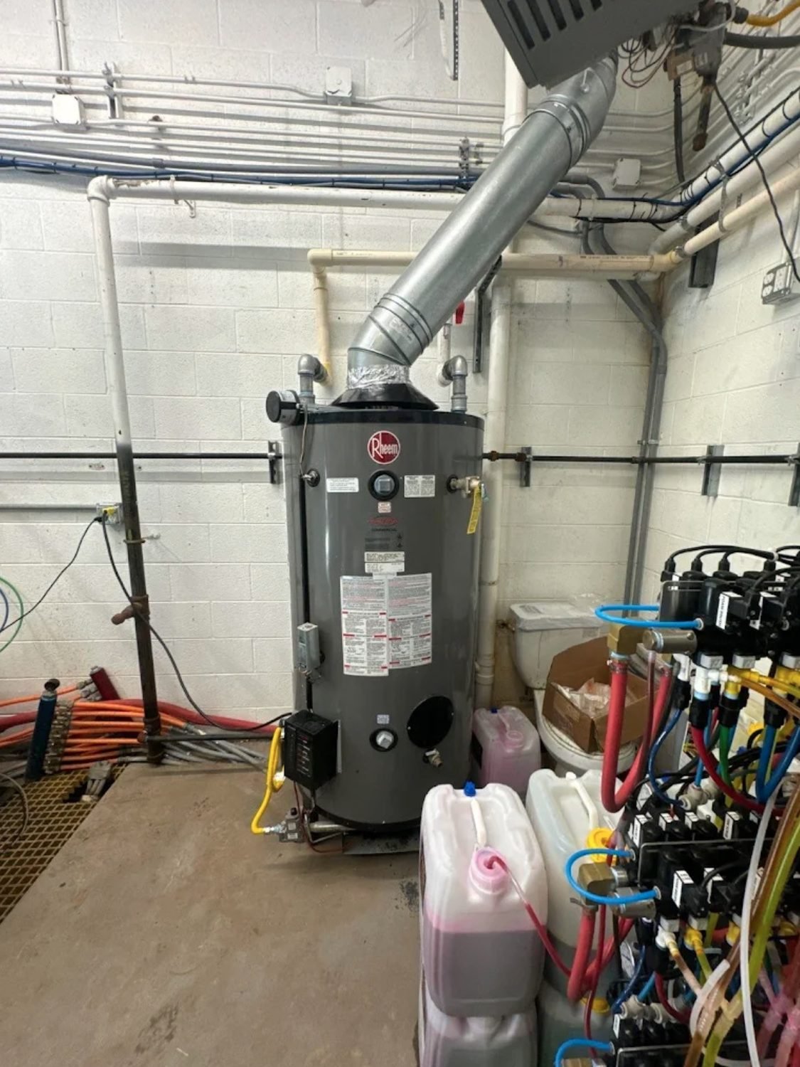 Commercial gas water heater with flue venting in a mechanical room