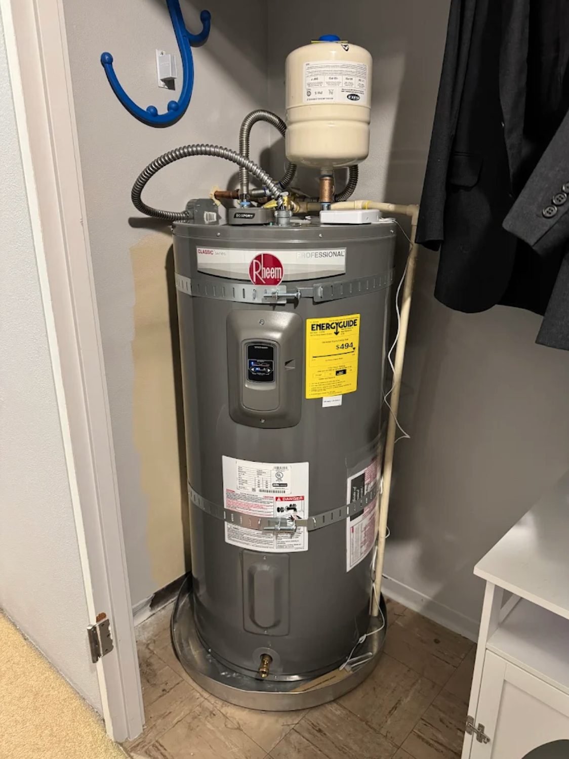 New electric water heater with an expansion tank installed in a closet
