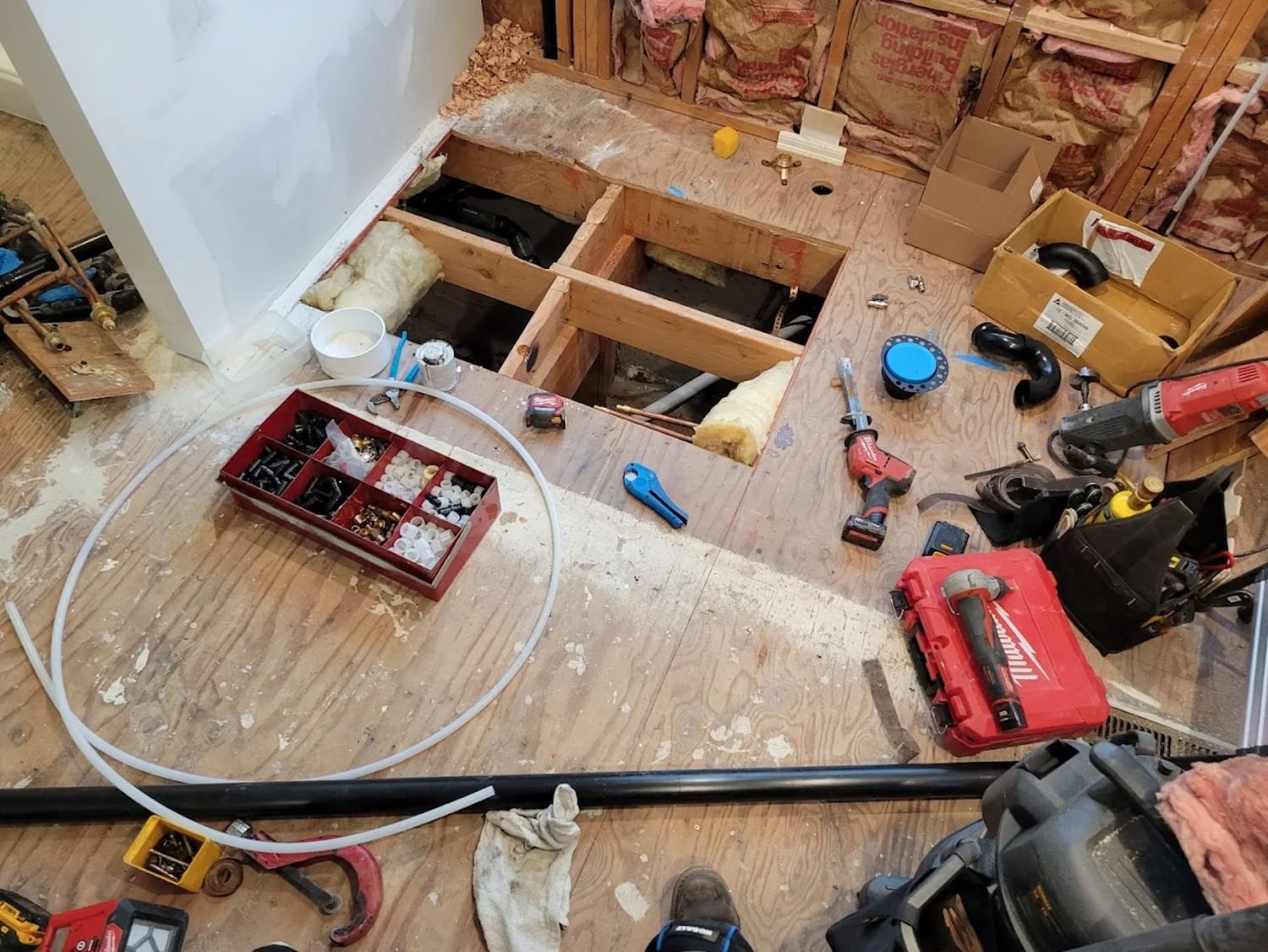 Floor opened between joists in a home for a repipe, work area protected