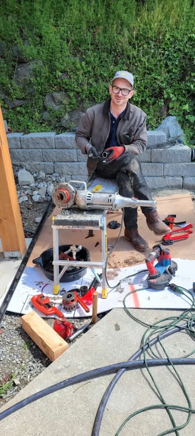 Technician using a power pipe threader on site