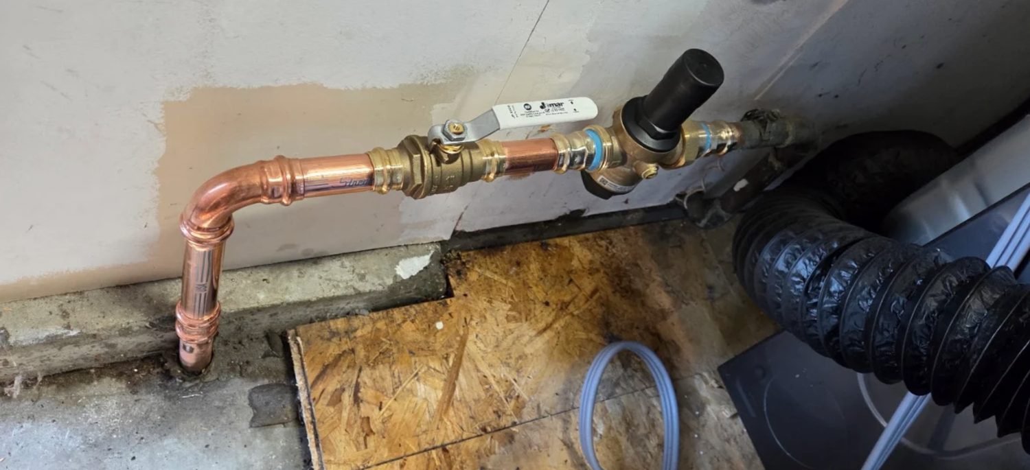 New copper piping with a pressure reducing valve and main shutoff at a wall