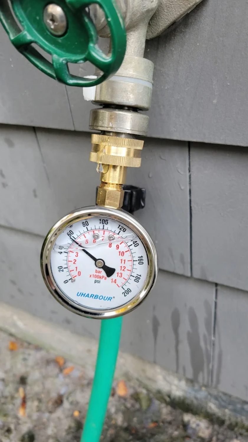 Pressure gauge attached to a new water line at a hose bib