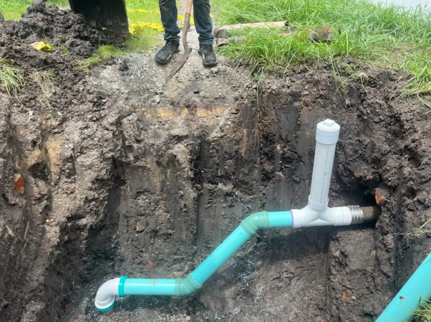 New PVC sewer line and cleanout tied into the existing pipe in an open trench