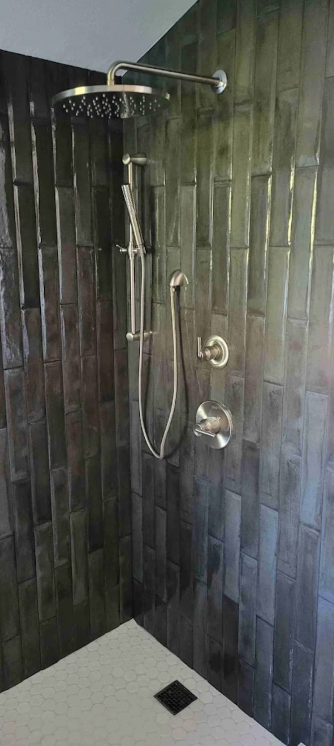 Finished walk in shower with a rain head and hand shower on a slide bar
