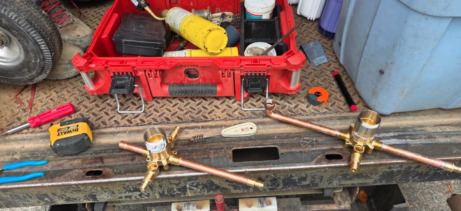 Two shower valve bodies with copper stub outs prepared on a truck bed