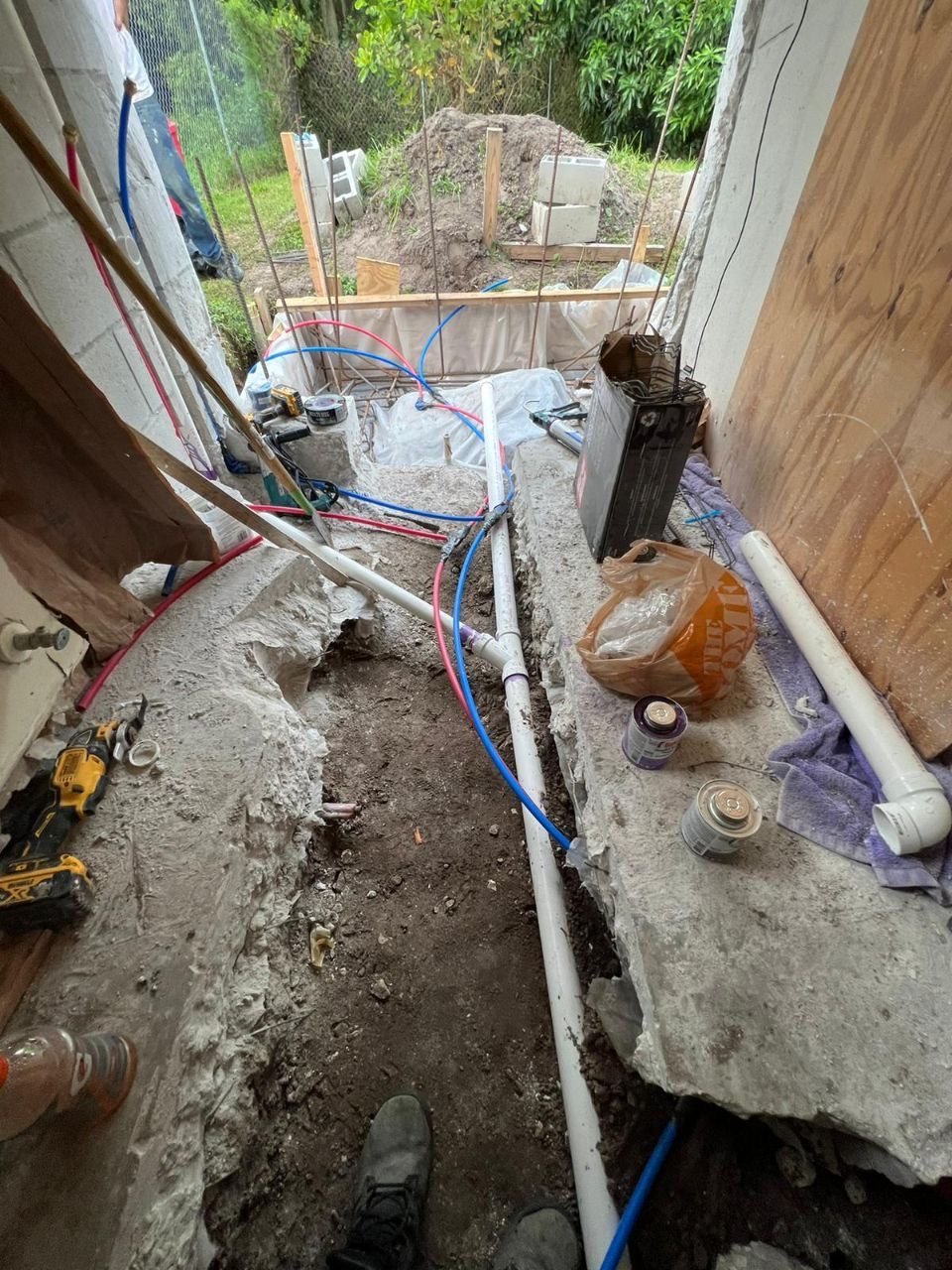Water lines run through a cut slab along the side of a house