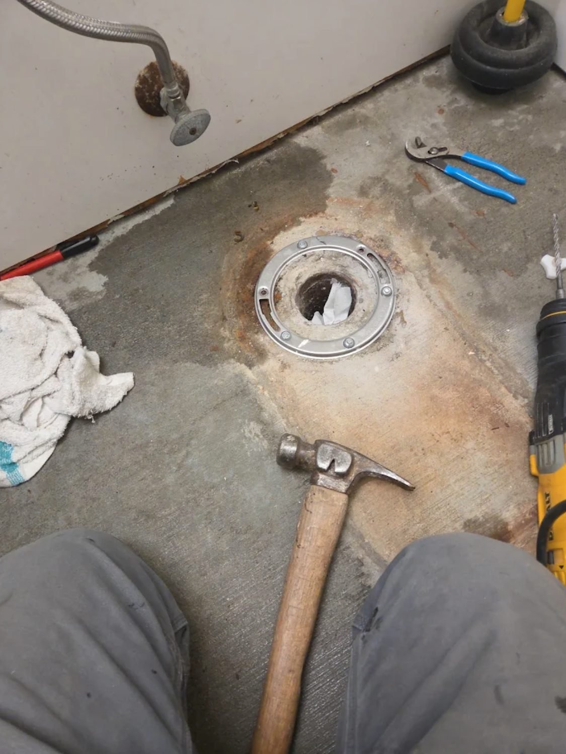 Corroded toilet closet flange exposed at floor level