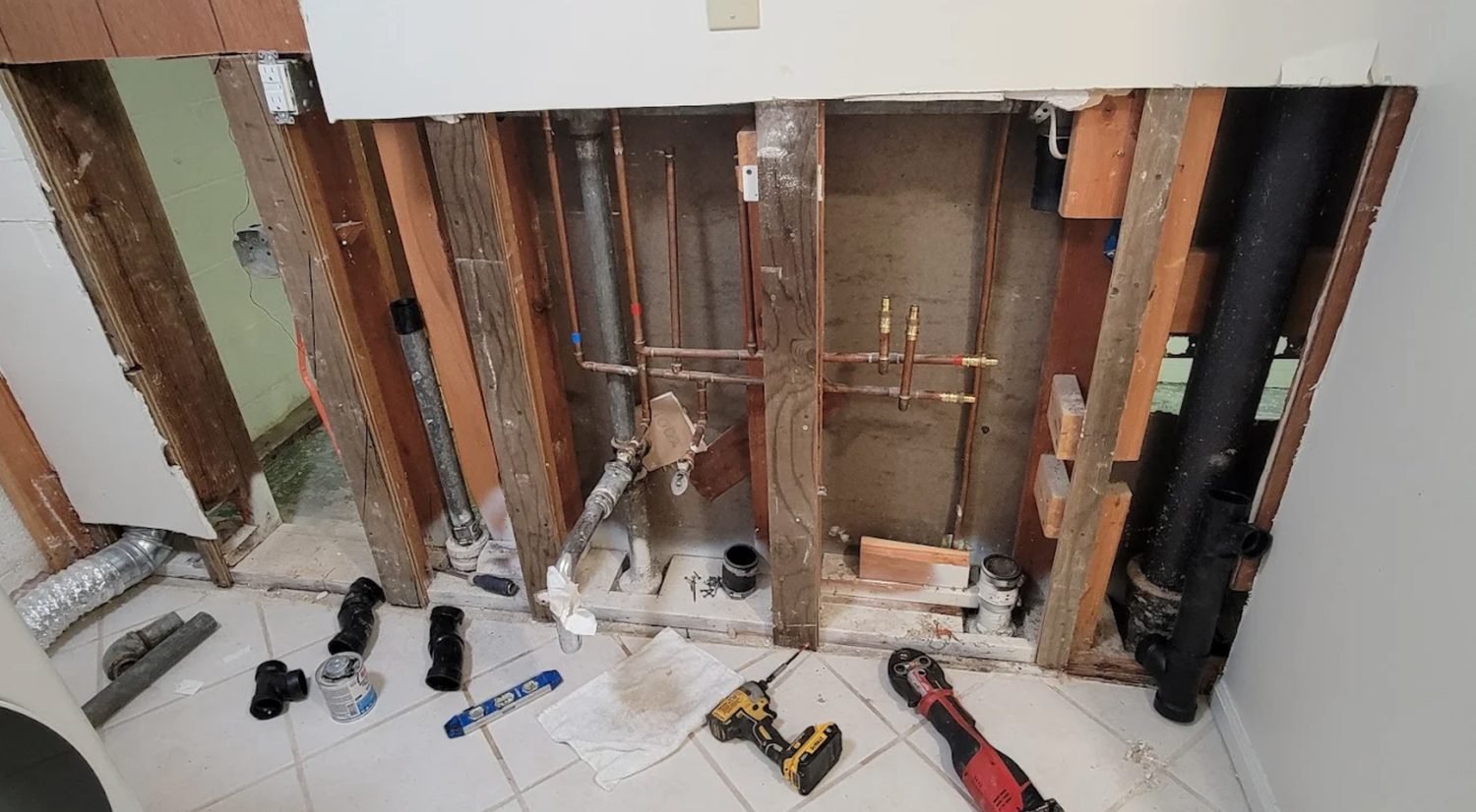 Wall opened to studs showing new copper supply lines and stub outs